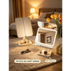 A tri-fold LED vanity mirror with dimmable lighting resting on a beige blanket in a bedroom setting.