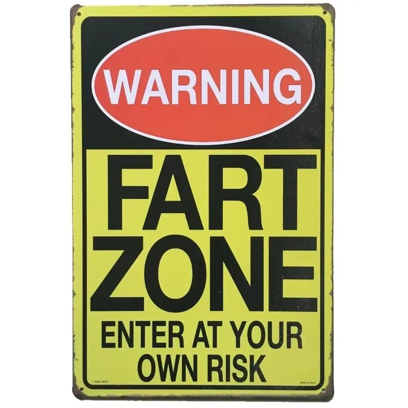 A vintage metal warning sign with a red oval reading WARNING and black text saying FART ZONE and ENTER AT YOUR OWN RISK on a 
