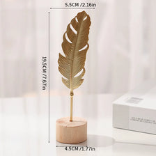 A gold-colored iron ginkgo leaf ornament mounted on a wooden base.