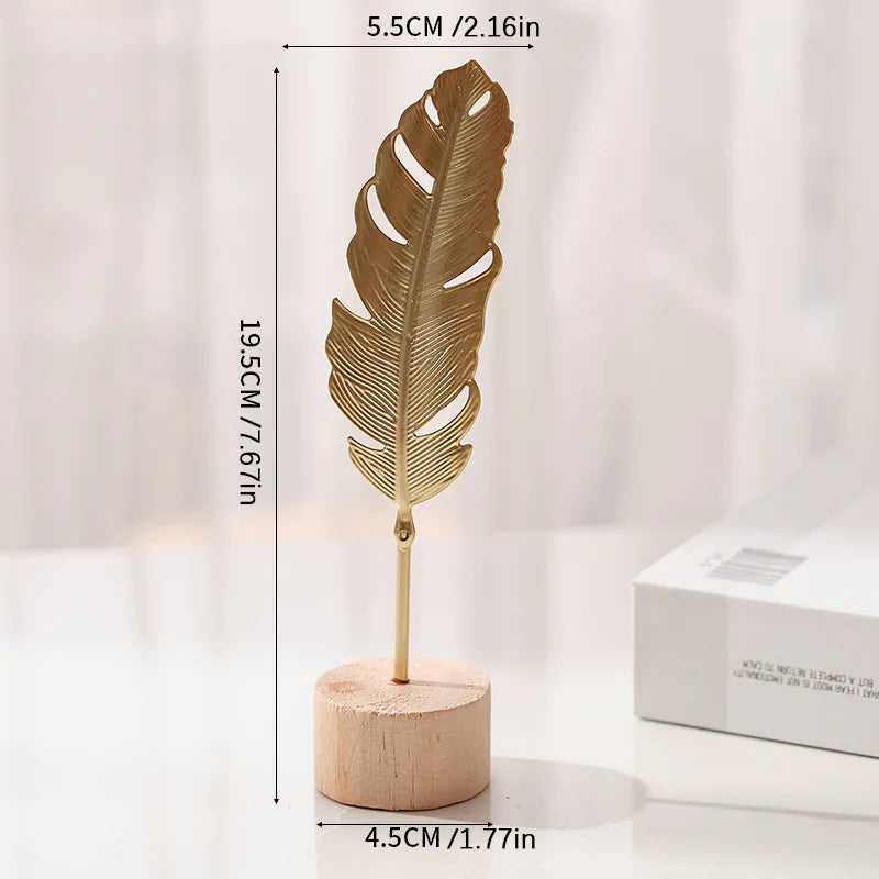 A gold-colored iron ginkgo leaf ornament mounted on a wooden base.