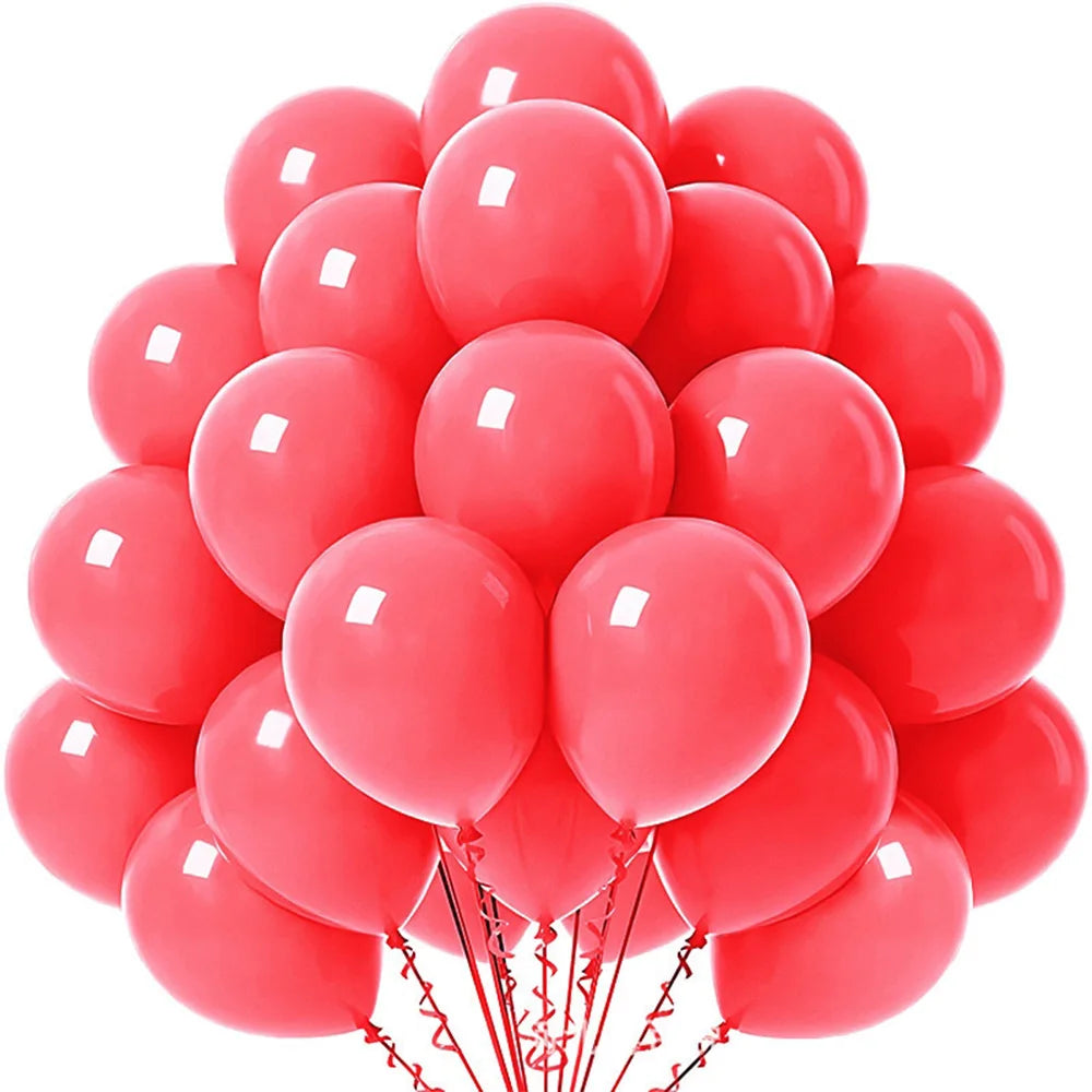 A bunch of pastel rainbow latex balloons in various shades of pink and red.