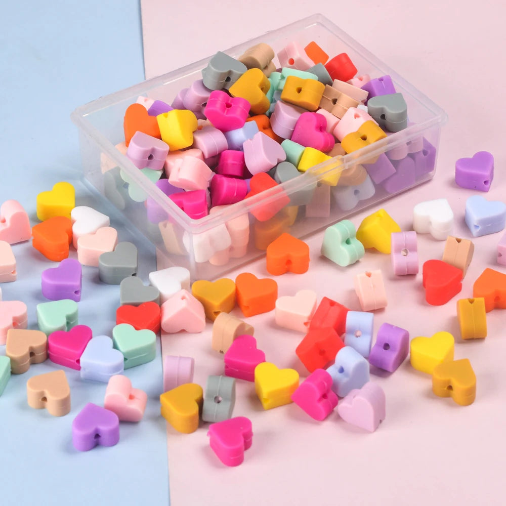 A clear plastic container filled with colorful silicone heart beads for DIY jewelry making