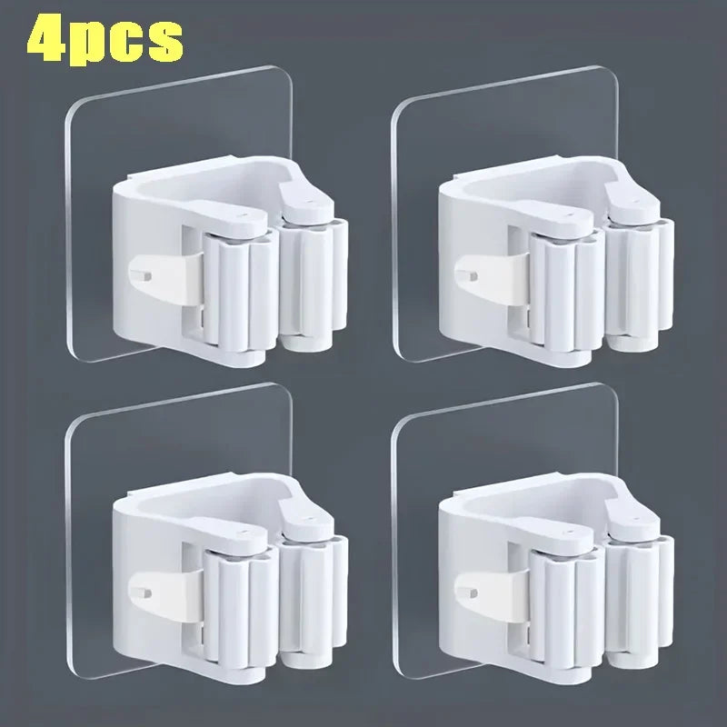 Four white wall mounted holders for storing mops and brooms.