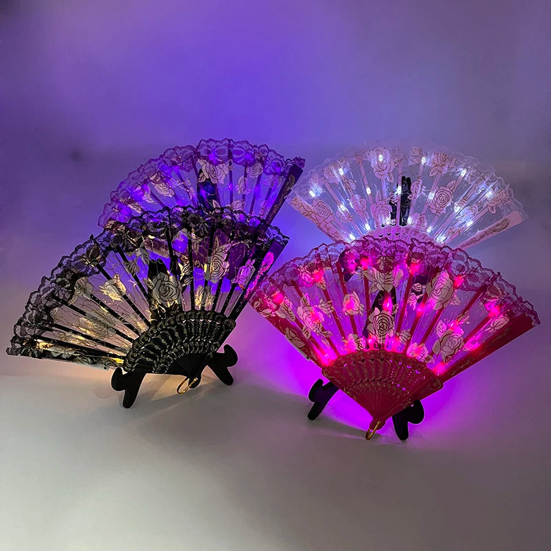 Three illuminated LED dancing hand fans in purple, white, and pink are displayed against a light background.