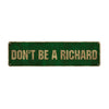 A rectangular, dark green metal sign with the text DON'T BE A RICHARD in gold lettering.