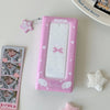 A pink photo booth album with a mirror and decorative elements is shown next to some photos.