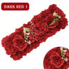 A dense panel of dark red artificial silk roses with green foliage for weddings and events.