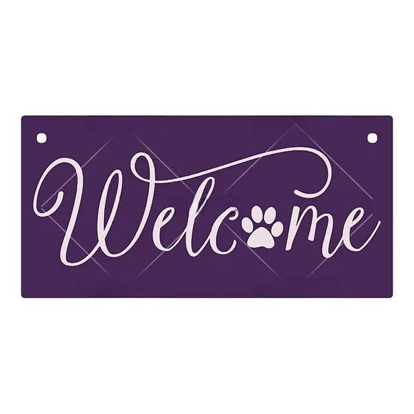 A purple wooden hanging sign with white script that reads Welcome and features a paw print.