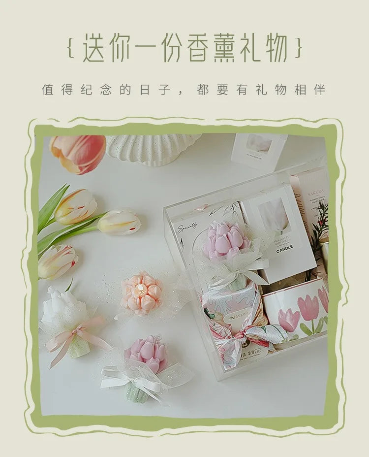 A clear box containing a pink and white artisan tulip bouquet and a soy wax candle.