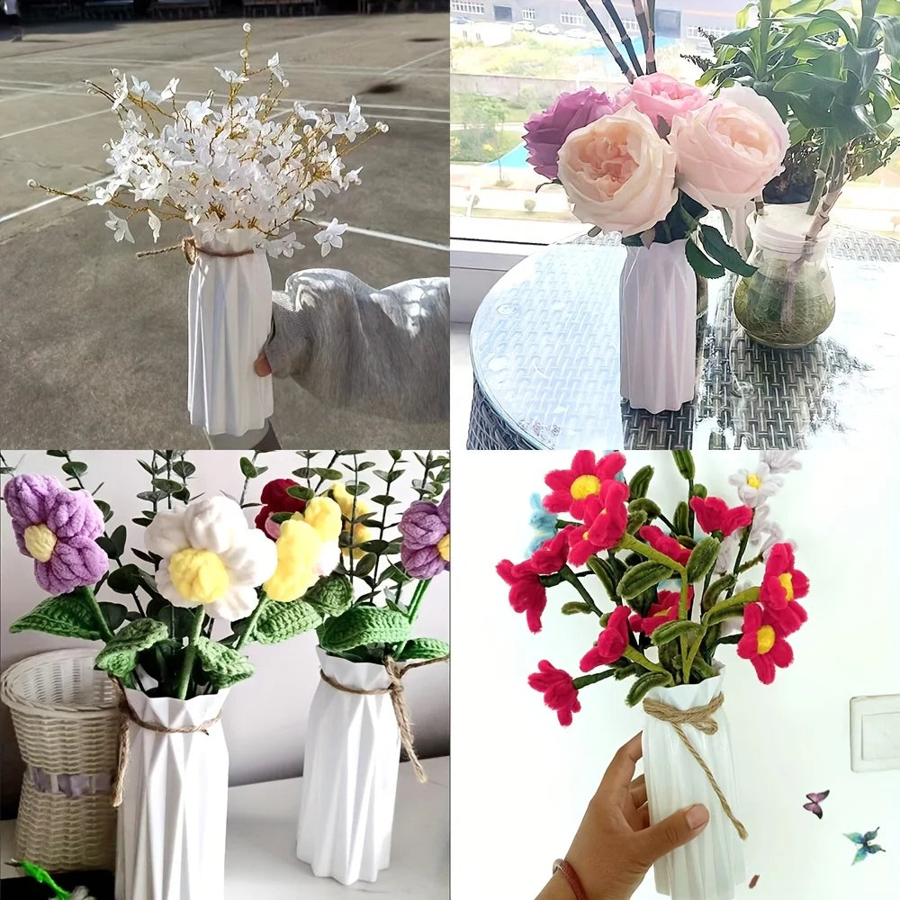 A collection of modern origami plastic vases in white and pink, featuring abstract folded designs.
