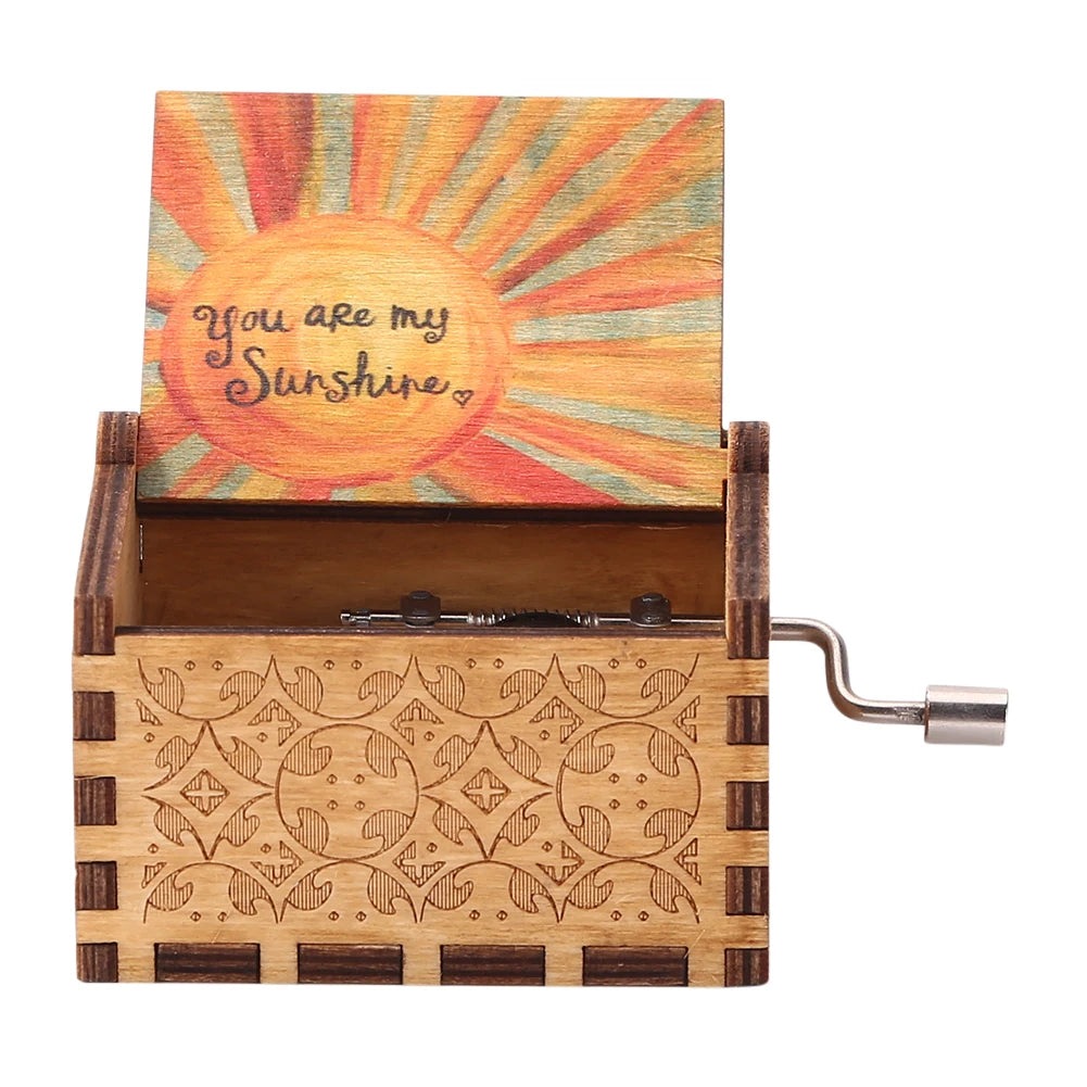 A wooden music box with a sun design and an engraved lid, featuring a hand crank mechanism.