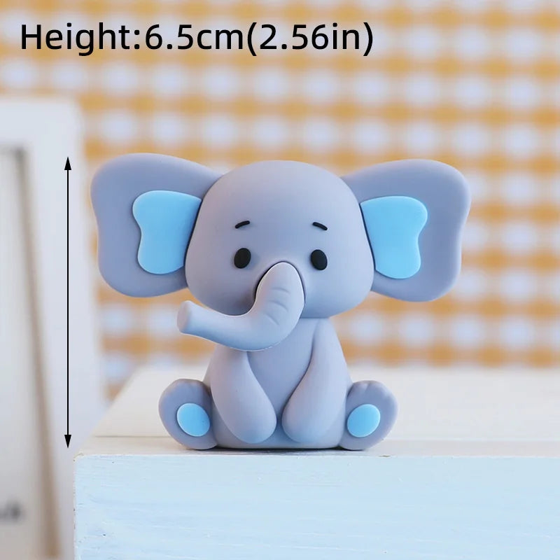 A small, gray cartoon elephant figure with light blue ears sitting on a white surface.