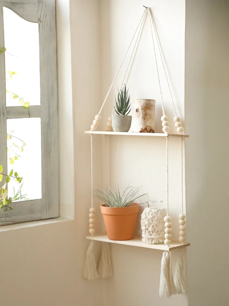 A rustic wooden wall shelf with macrame hangers displaying potted plants and decorative items.