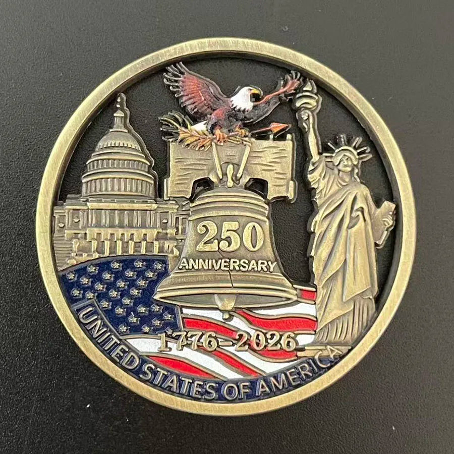 A round gold-toned collectible coin featuring a statue of Liberty, an eagle, and the text 1776-2026 for the United States of 
