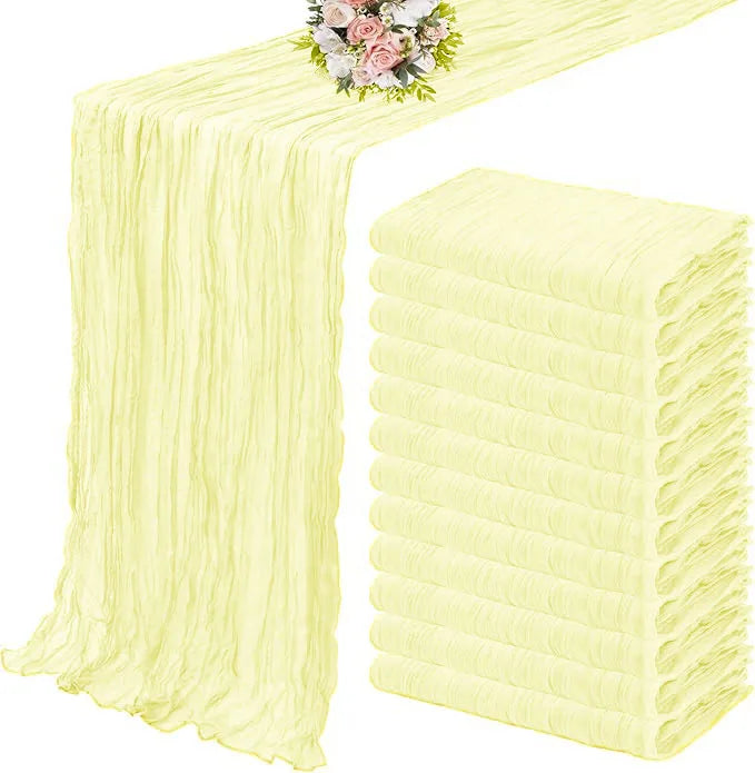 A set of ten terracotta semi-sheer cheesecloth table runners in pale yellow, displayed on a table.