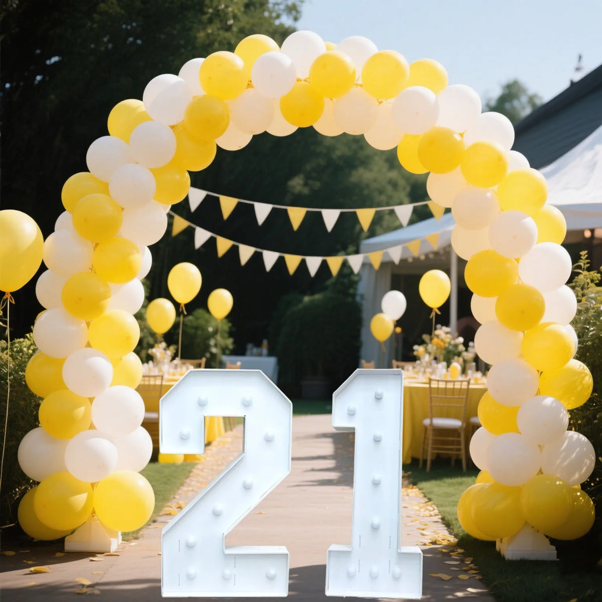 A yellow and white balloon arch decorated with a large light-up marquee number 21 for an event.
