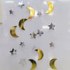 A vertical display of metallic gold and silver star and crescent moon shapes used for a party bunting.