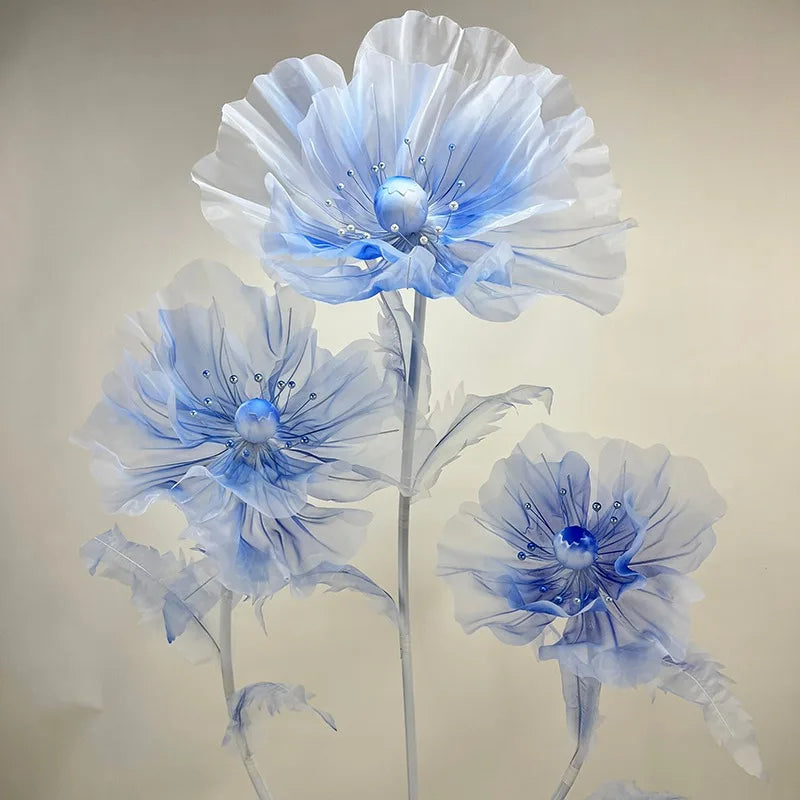 A set of three large, light blue velvet mesh flowers used for wedding decoration.