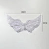 White angel feather wings costume prop with adjustable straps displayed against a white background.