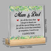 A clear acrylic plaque with the text Mum & Dad and I love you engraved on it, set in a wooden frame.