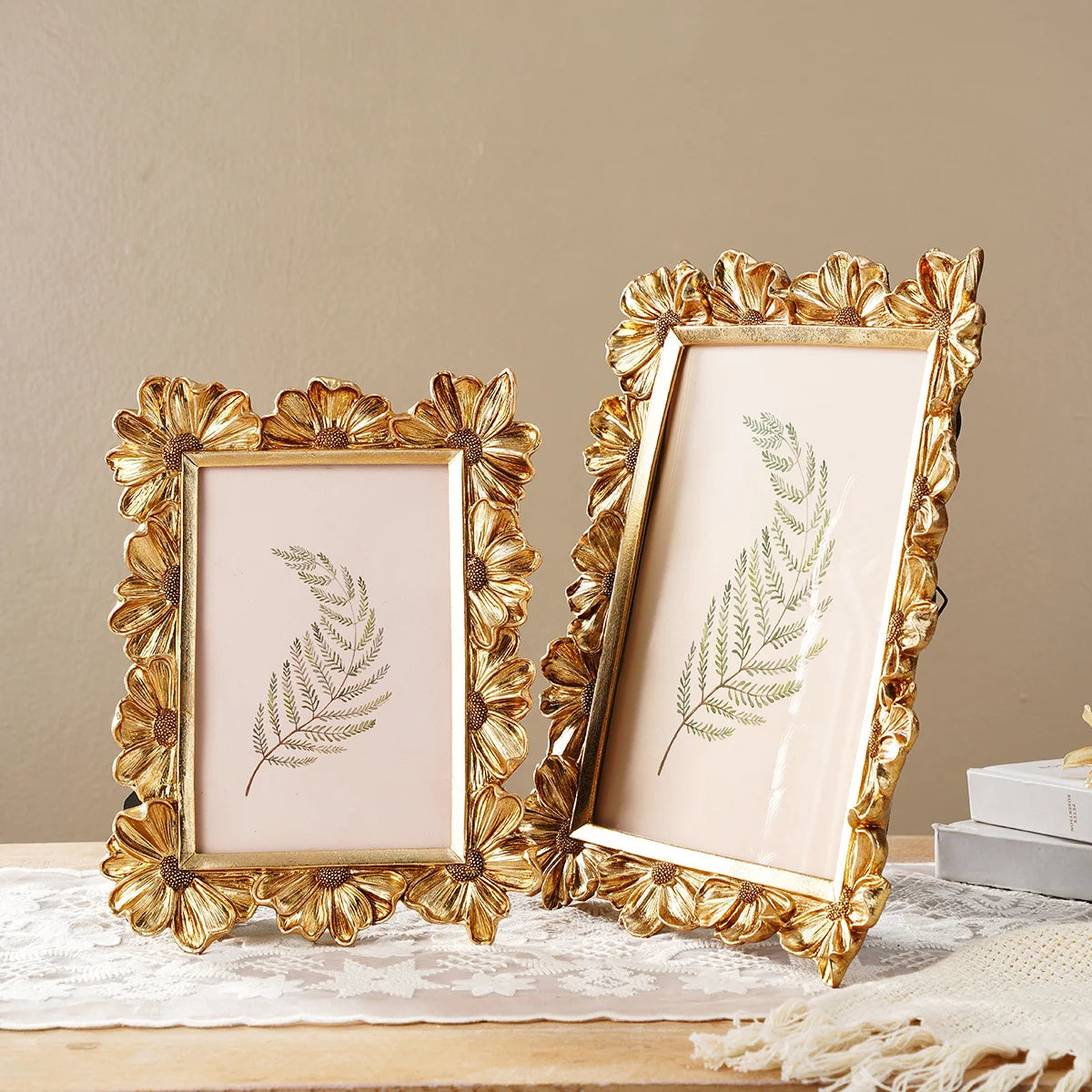 A golden 3D resin photo frame with a floral design is displayed on a wooden surface.