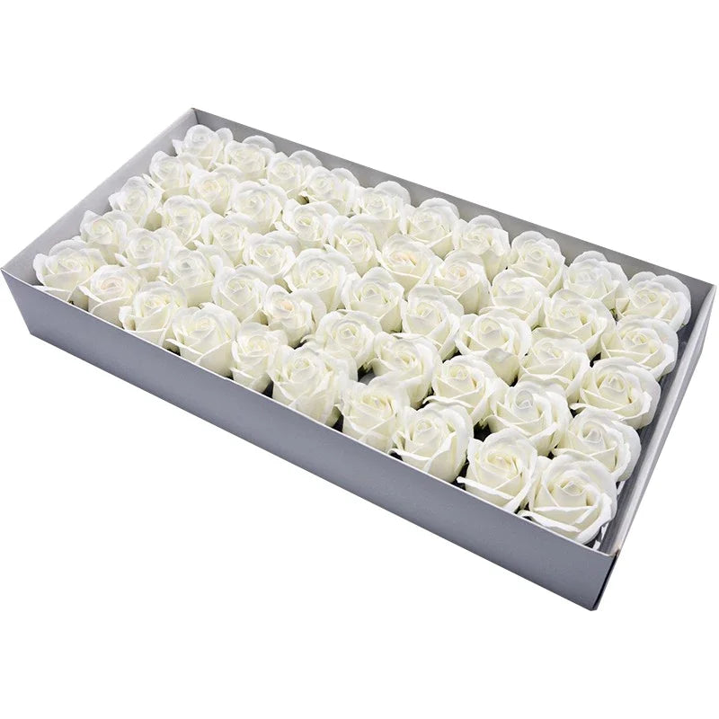 A rectangular box filled with numerous white artificial rose heads for wedding and party decor.