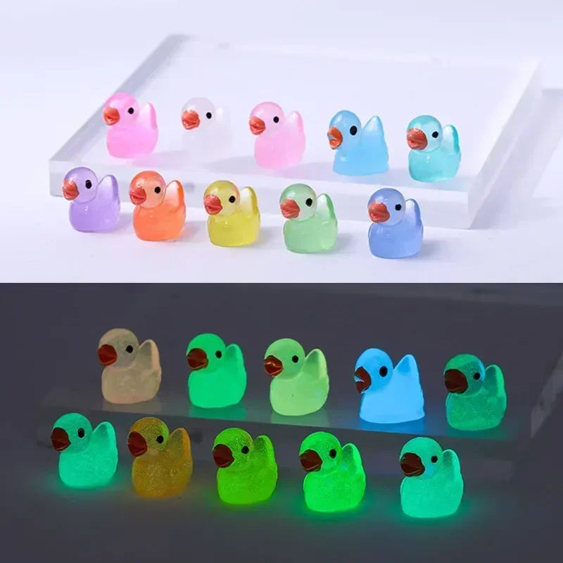 A collection of luminous mini duck figurines in various pastel and bright colors arranged in a white display box.