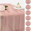 A set of vintage bud glass vases in a dusty rose color displayed on a draped fabric.