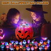 A collection of Halloween glow rings and pumpkin-themed items displayed in front of two children with carved faces.