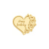 A gold heart-shaped acrylic cake topper with butterfly designs and the words Happy Birthday.