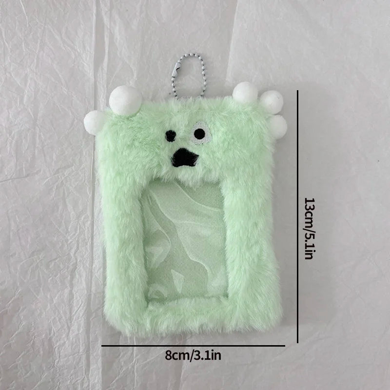 A light green fluffy plush keychain featuring a face and a clear plastic holder for photos.