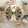 A round metal wall clock with a gold-toned branch design and a silver face, featuring ginkgo leaf accents.