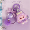A purple fluffy heart plush keychain charm with a pink bow and purple bead on a silver ring.