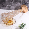 A gold crystal flower vase with a textured body and a round gold lid rests on a white marble surface.