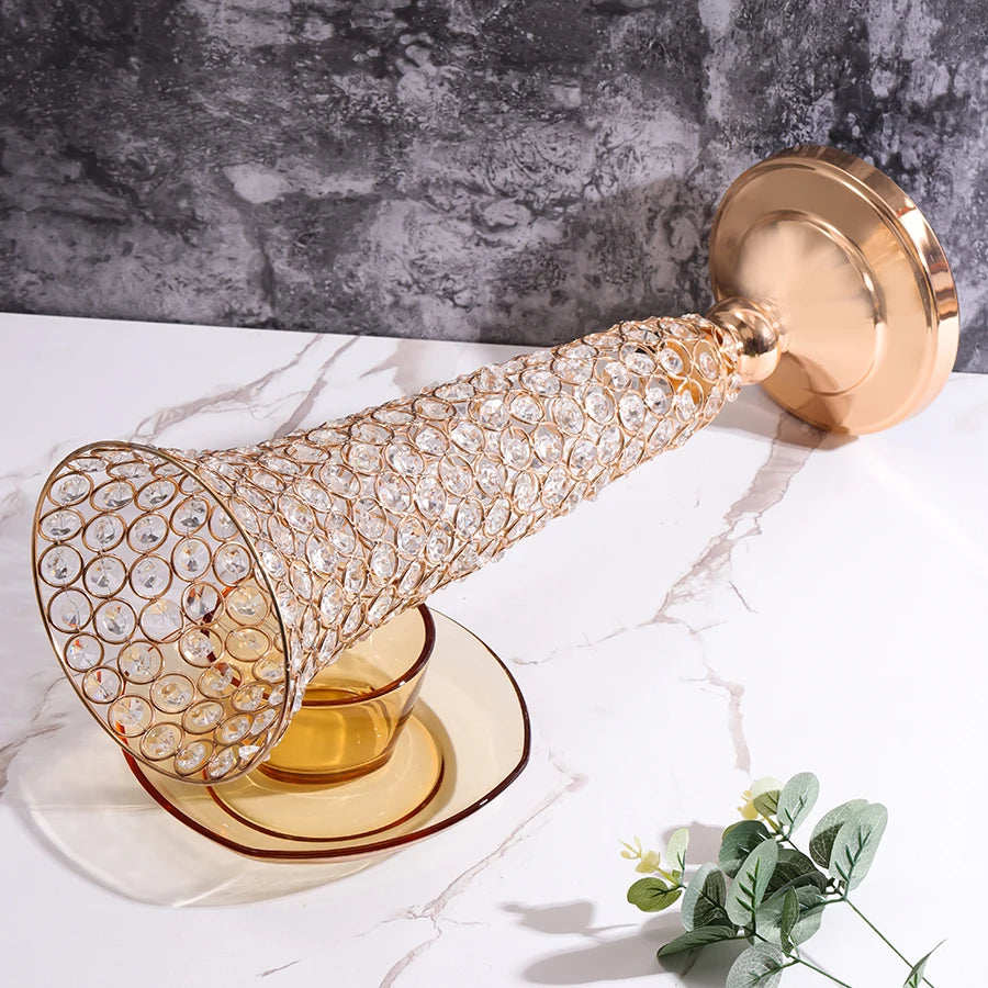 A gold crystal flower vase with a textured body and a round gold lid rests on a white marble surface.
