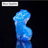 Figura de opalita azul translúcida con forma de animal saltando, reflejando luz en una superficie oscura.