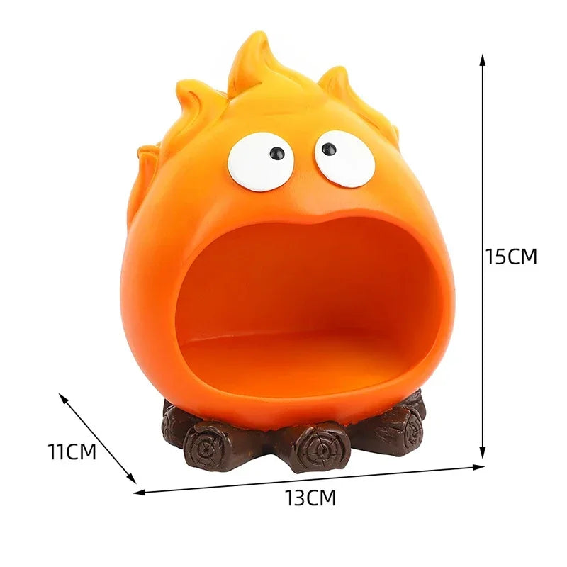 An orange resin figure shaped like a roaring fire spirit, used as a key tray or desk organizer.