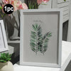 A framed botanical print featuring a green palm leaf on a white background.