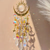 A hanging gold star moon wind chime featuring clear crystals and gold accents against a light background.