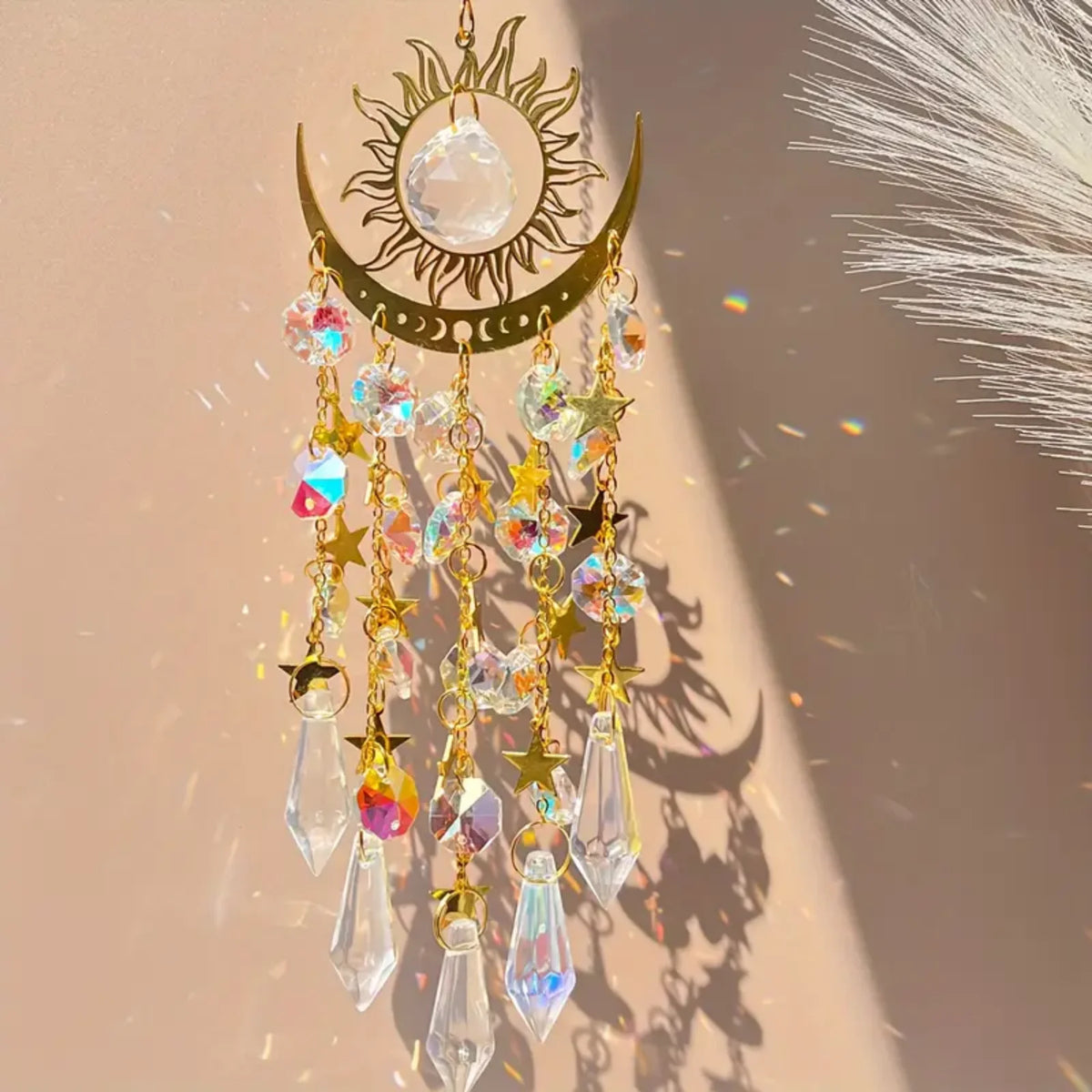 A hanging gold star moon wind chime featuring clear crystals and gold accents against a light background.