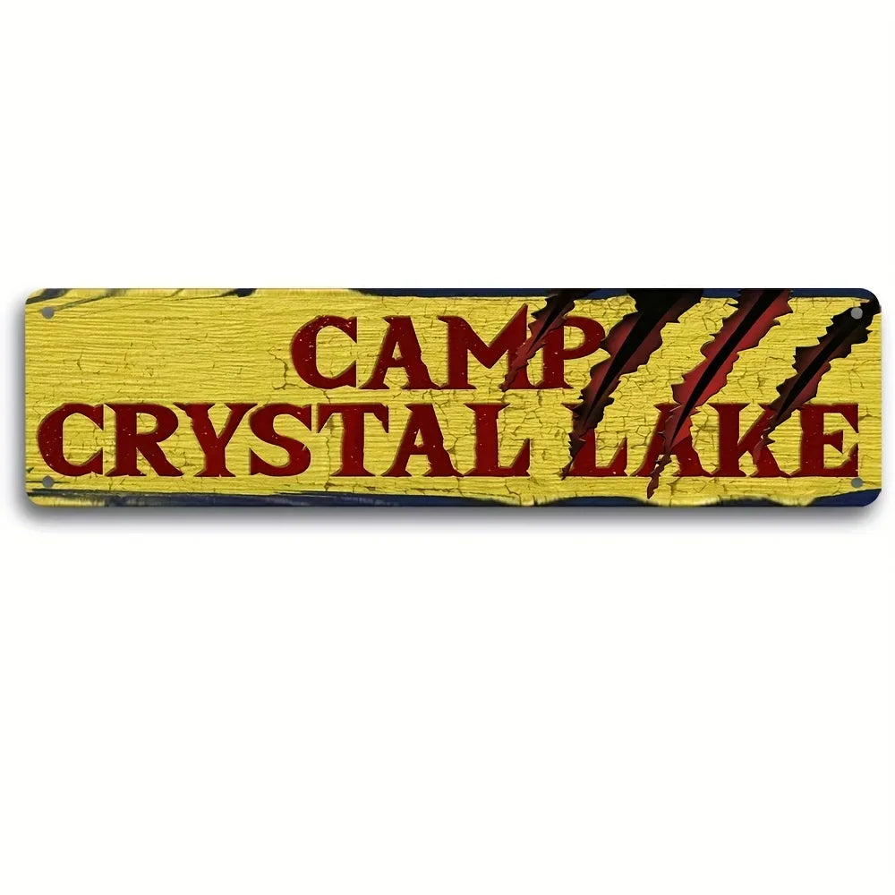 Vintage metal wall sign with the text CAMP CRYSTAL LAKE in distressed red lettering on a yellow background.