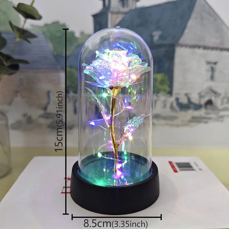 A glass dome containing an eternal rose with glowing purple and green LED lights on a black base.