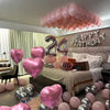 A display of pink and silver balloons decorating a room for a happy birthday celebration.