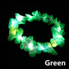 A glowing green LED flower crown headband with small lights against a black background.