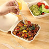 A hand is using a spoon to serve a savory meat and vegetable dish in an open plastic container.