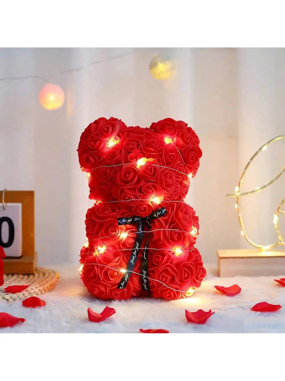 Helles rotes Kunstblumen-Teddybär mit warmen LED-Lichtern auf weißem Untergrund.