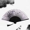 A black and white photograph of a vintage bamboo folding hand fan with delicate plant details and a small bird flying nearby.