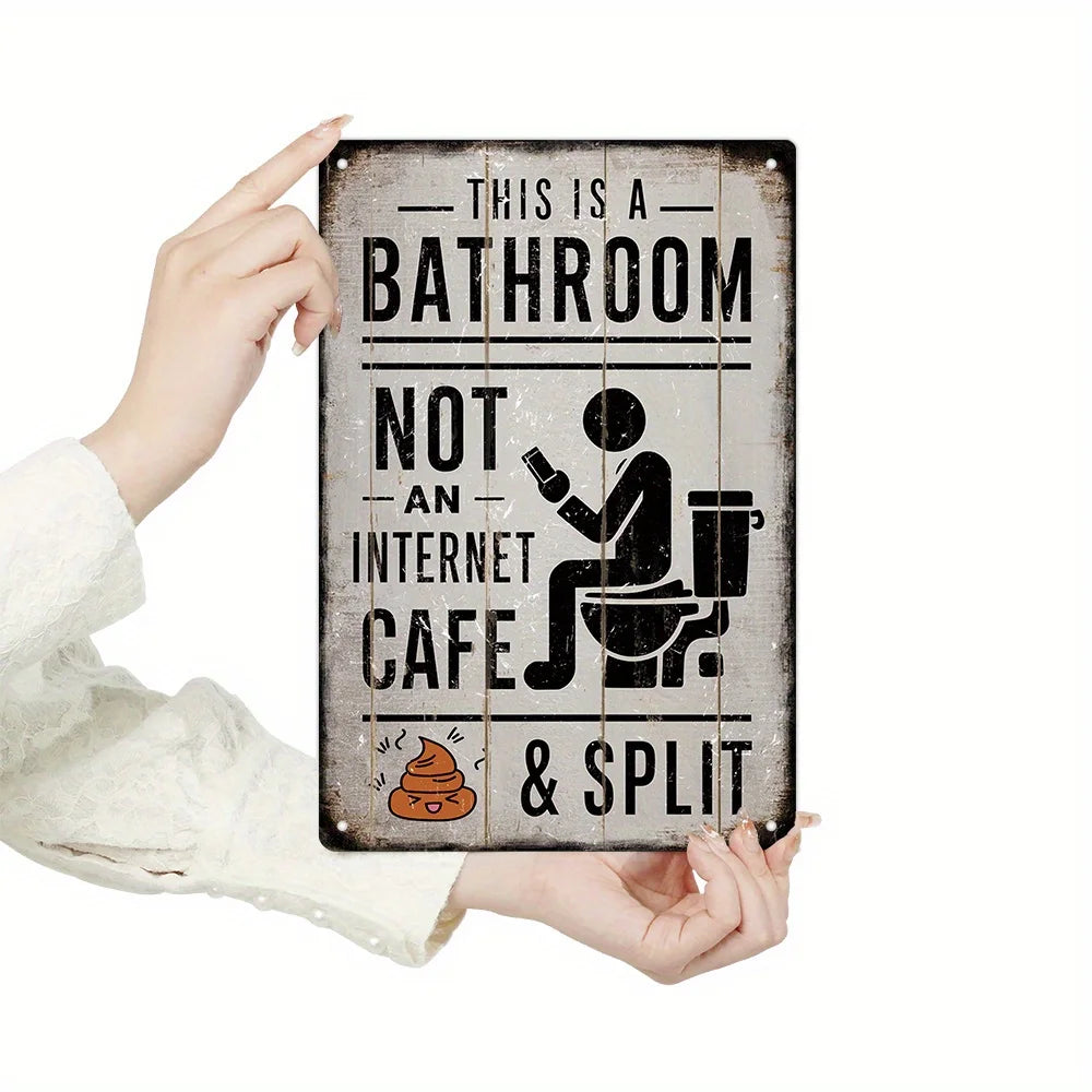A weathered metal sign reads This is a bathroom not an internet cafe & split, held by a hand.