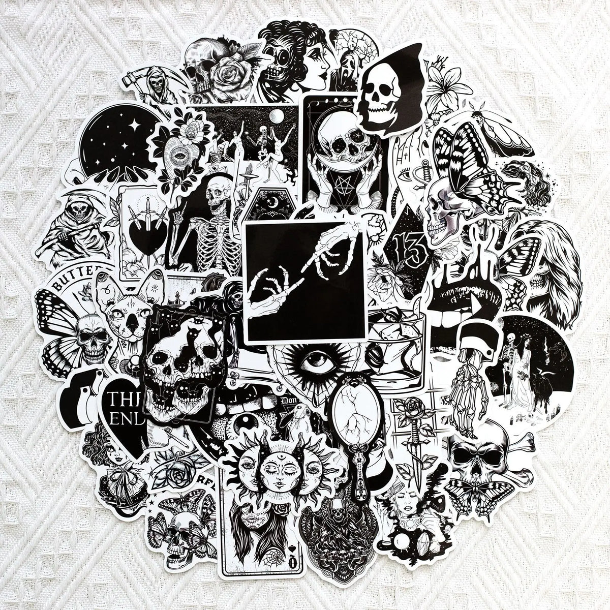 Collection d'autocollants en vinyle de crânes gothiques noir et blanc avec divers designs macabres.
