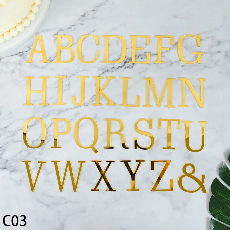Gold acrylic alphabet letter cake topper set spelling out the entire English alphabet and ampersand on a white marble surface